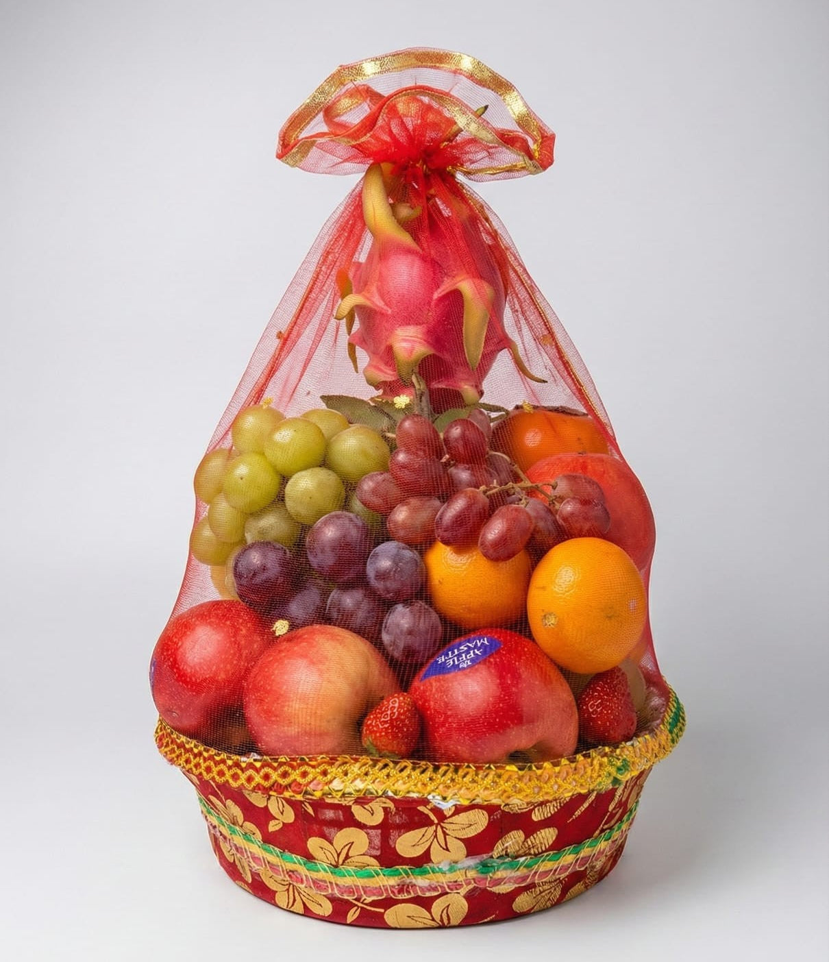 Fruit basket with a variety of fruits in a decorative bag on a white background
